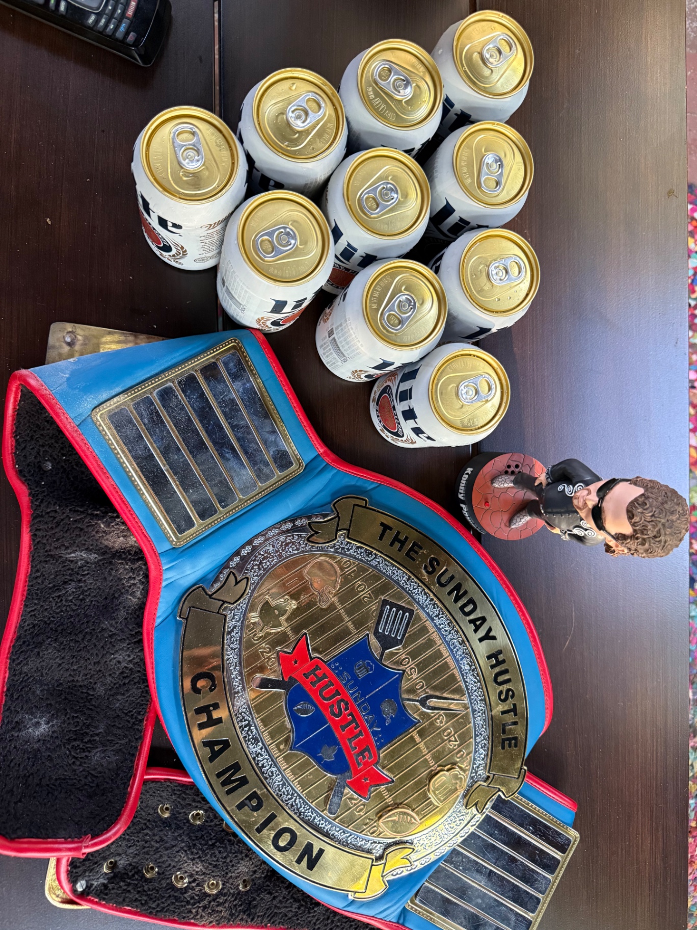 Championship belt, Kenny Powers bobblehead and a stack of cold beers on a table