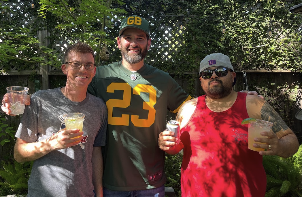 Hustle owners raising drinks in the backyard