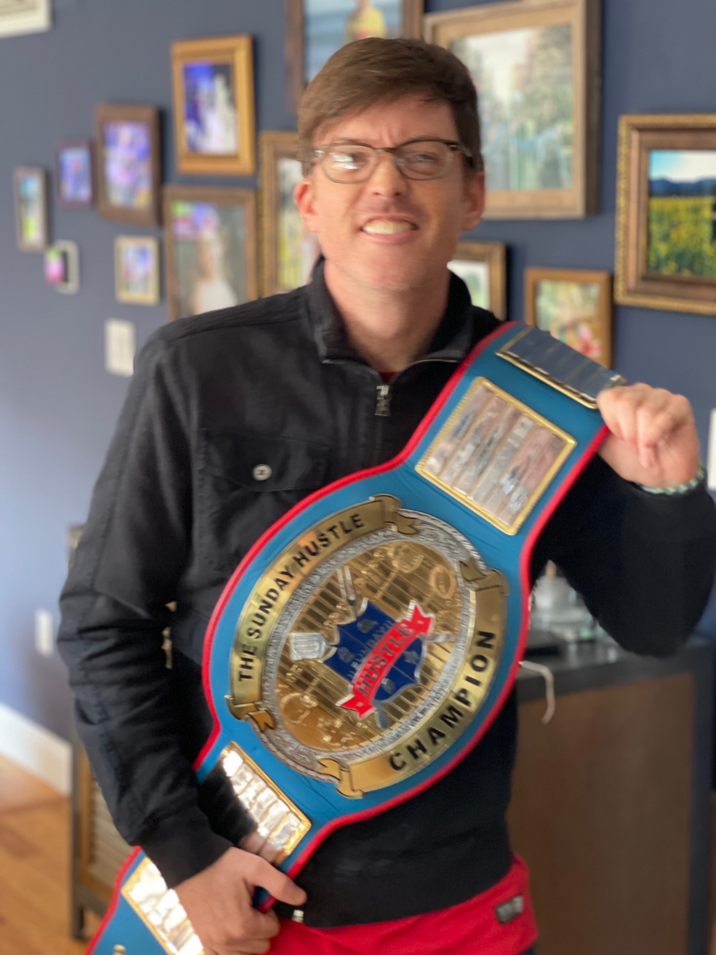 Sunday Hu$tle champion posing with the belt over his shoulder
